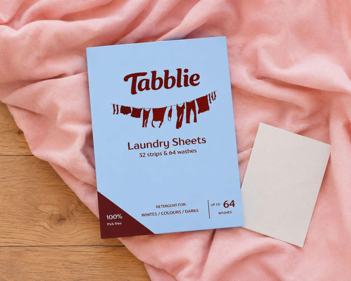 Pak Tabblie Wasstrips op roze beddengoed met een losse wasstrip ernaast