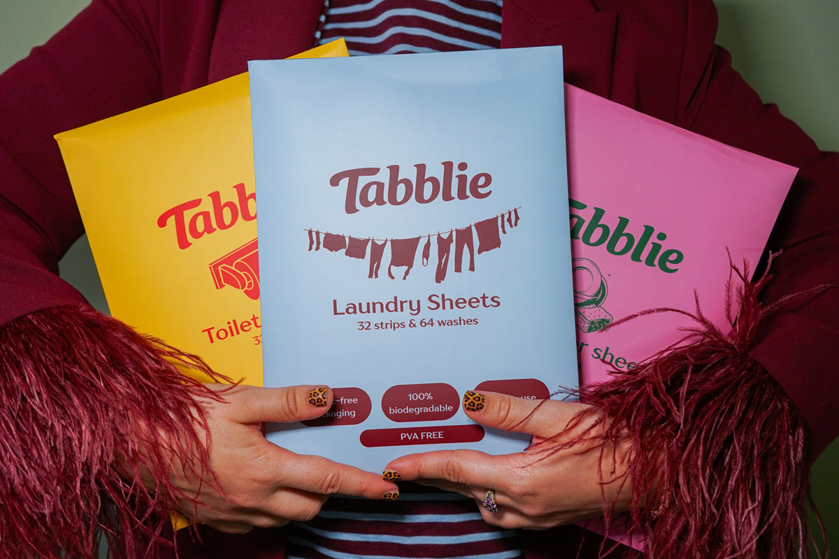 Handen met de Tabblie wasstrips, vaatwasstrips en toiletstrips, pakken zonder plastic