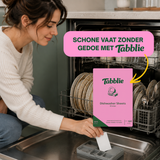 Vrouw legt een Tabblie vaatwasstrip in het tabletvak van de vaatwasser